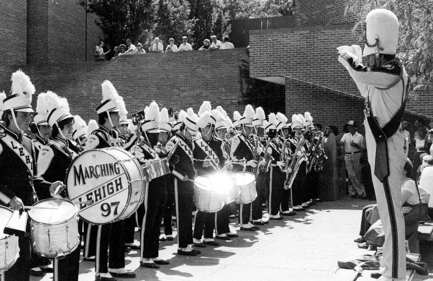 The Marching 97 playing in lines, with the Drum Major conducting in front