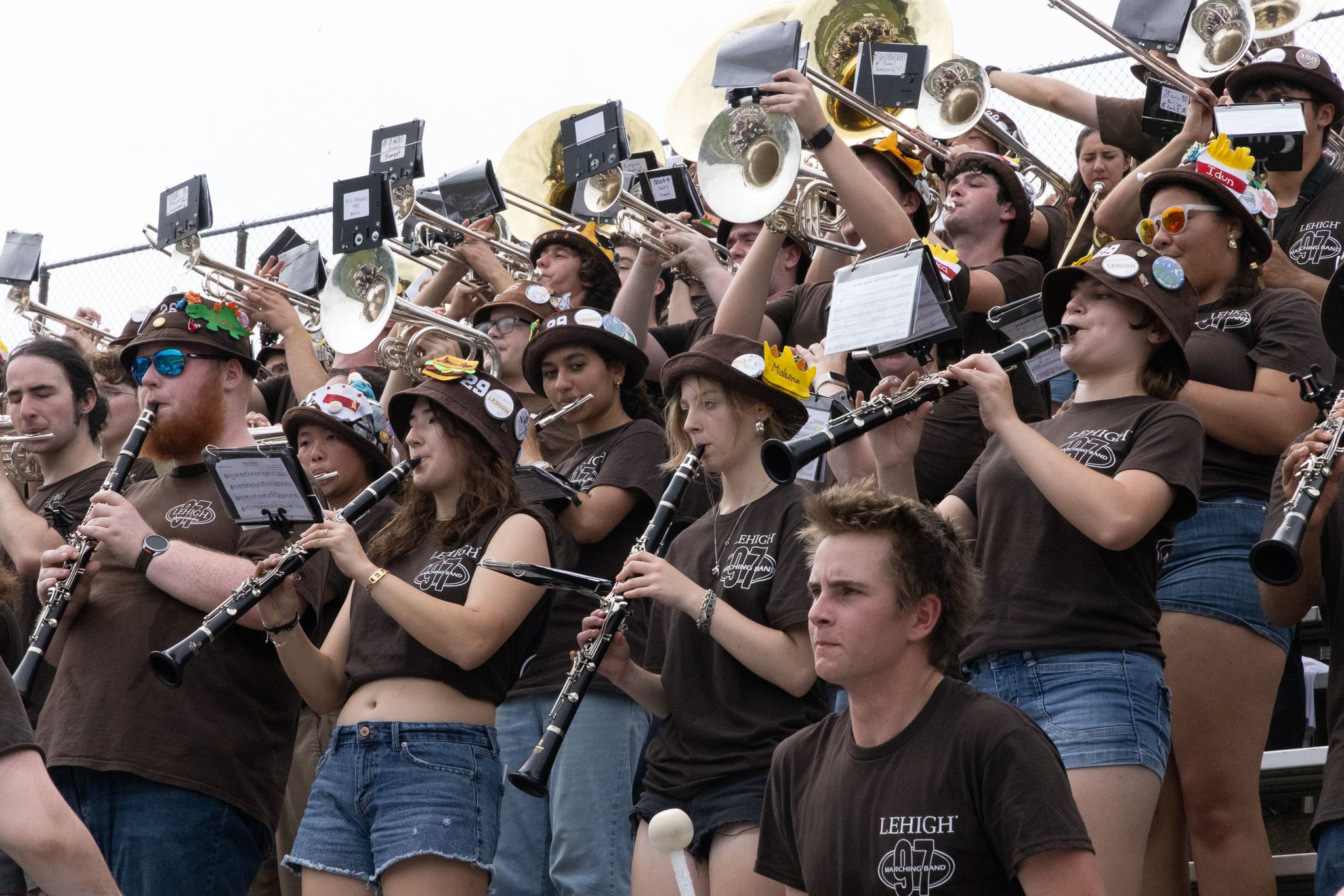 The band playing in the stands with clarinets in front, followed by mellophones, trumpets, and trombones