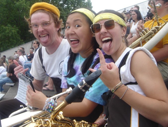 Three 97 members pose with their tongues out in the stands