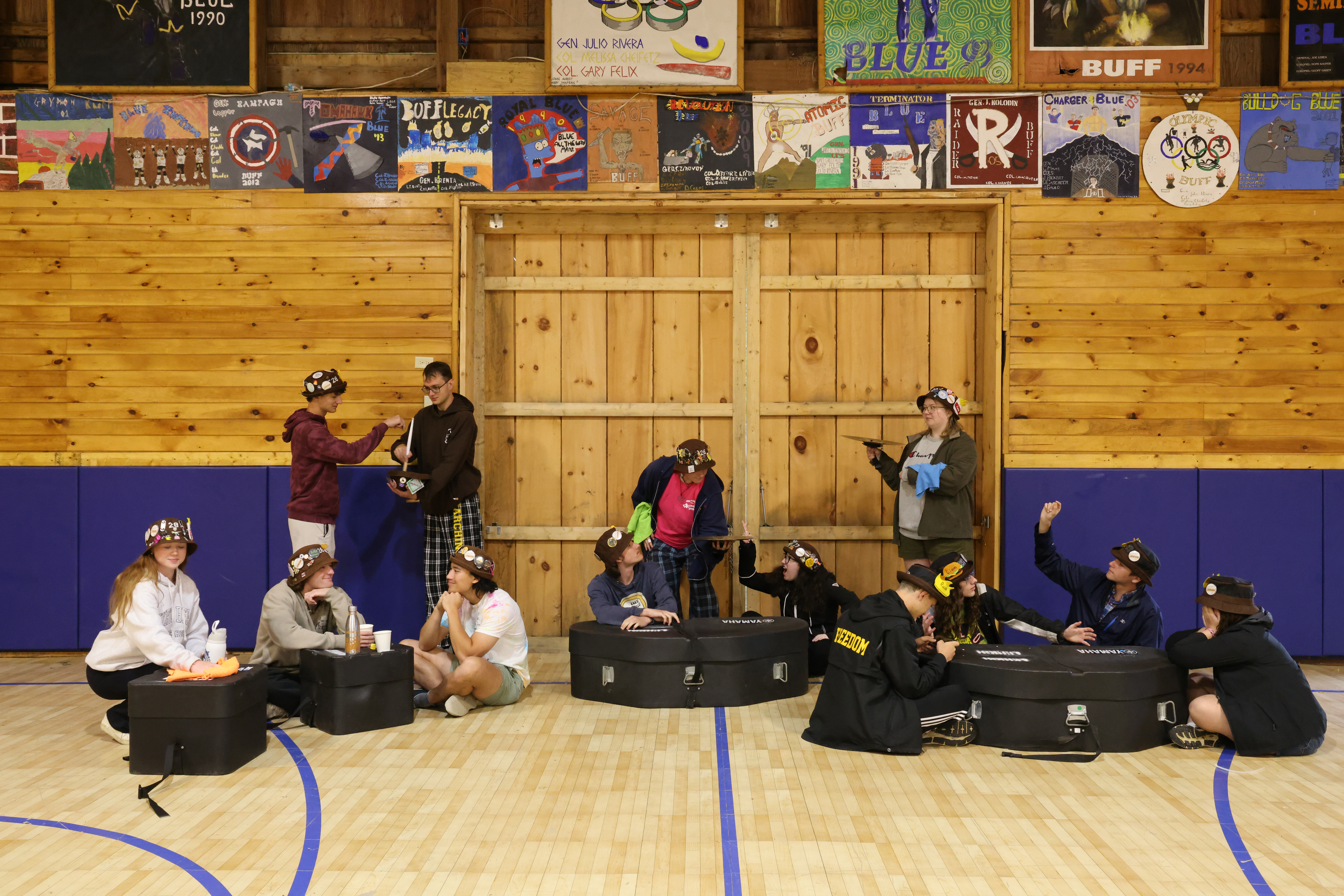 Ranks 3 and 12 pretending to be at a restaurant by using drum cases as tables and cymbals as plates.
